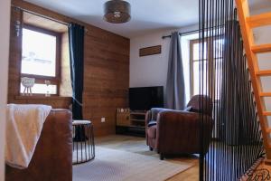 a living room with two chairs and a television at Gîte de la Ravanne in Ramonchamp