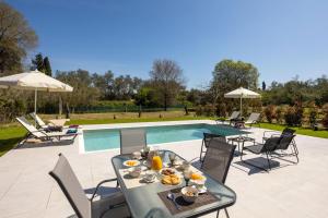 a table with food on it next to a pool at VILLA ELENA PRIVATE POOL Kontokali villas in Kontokali
