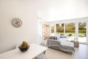 a white living room with a couch and a clock at VILLA ELENA PRIVATE POOL Kontokali villas in Kontokali