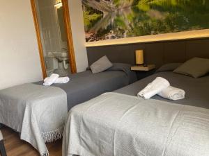 2 camas en una habitación con un cuadro en la pared en Hostal Restaurante Río Ubierna, en Quintanilla-Vivar