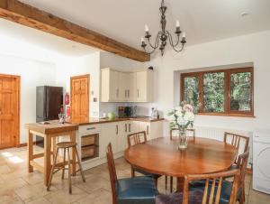 a kitchen with a wooden table and a dining room at Long House in Beaumaris