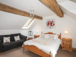 a bedroom with a bed and a couch at Long Cottage in Beaumaris