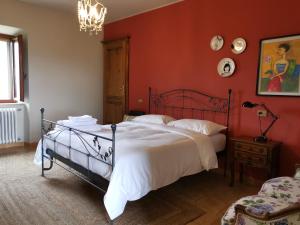 una camera da letto con un grande letto con pareti rosse di Podere Campiano a Volterra