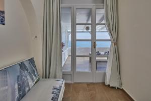 Habitación con vistas al océano a través de una ventana en Soultouch Beachfront Villa, en Perissa