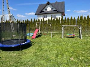 a group of playground equipment in a yard with a house at Zajazd Gronków in Gronków