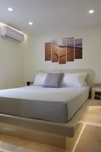 1 dormitorio con 1 cama con 2 cuadros en la pared en Soultouch Beachfront Villa, en Perissa 33 fotos más