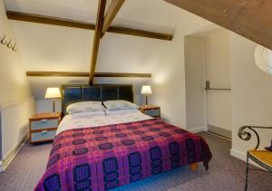 a bedroom with a large bed with a red and purple blanket at Cilie Tresaith in Penbryn