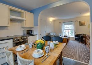 a kitchen and dining room with a wooden table at Cilie Tresaith in Penbryn