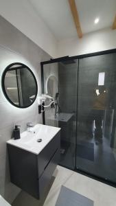 a bathroom with a sink and a shower with a mirror at Willa Lawenda- Przytulny Domek in Rytro