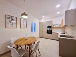 a kitchen and dining room with a wooden table and chairs at Costa Getaria - Iberorent Apartments in San Sebastián