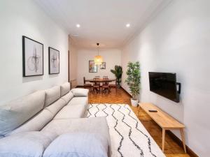 a living room with a white couch and a tv at Costa Getaria - Iberorent Apartments in San Sebastián