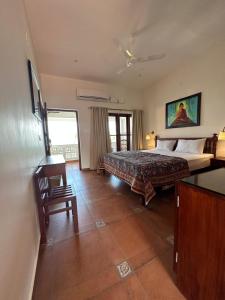 可瓦蘭的住宿－Buddha Beach Hotel，卧室配有1张床、1张桌子和1把椅子