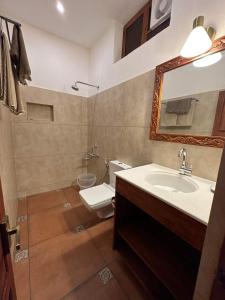 a bathroom with a sink and a toilet and a mirror at Buddha Beach Hotel in Kovalam