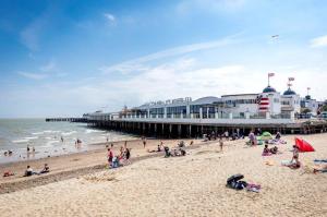 a group of people on the beach near a pier at Arizona - Pura Vida Holidays Caravan in Clacton-on-Sea