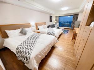 pokój hotelowy z 2 łóżkami i dużym oknem w obiekcie Artistic Studio w mieście Taizhong