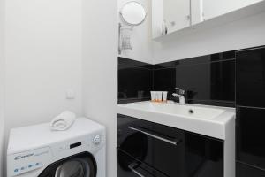 uma casa de banho com uma máquina de lavar roupa e um lavatório em Comfy & Trendy Studio Apartment Warsaw Wola by Renters em Varsóvia