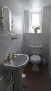 y baño con lavabo, aseo y espejo. en AROHA en Glastonbury