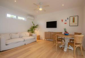 un soggiorno con divano bianco e tavolo di SALTY SNOOZE - Your Coastal Holiday House a Avalon