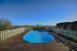 a small blue swimming pool on a wooden deck at Prestige for Home - Moradia com Piscina, Jardim e Estacionamento Paderne /Albufeira in Albufeira