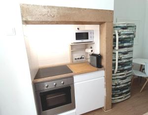 a small kitchen with a stove and a microwave at 10 MARIA - Faro in Faro