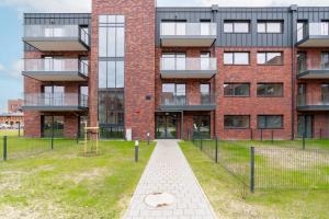 a brick building with a walkway in front of it at Stara Cegielnia Lake View Apartment by Renters Prestige in Poznań