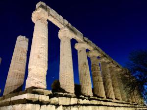 Un antiguo templo con columnas por la noche. en La terrazza sul mare, en Sciacca