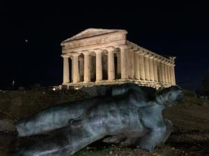 una estatua delante de un edificio por la noche en La terrazza sul mare, en Sciacca
