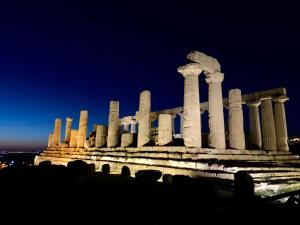 un edificio clásico con columnas por la noche en La terrazza sul mare, en Sciacca