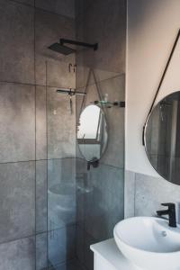 a bathroom with a shower with a sink and a mirror at The winelands in Cape Town