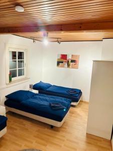 2 Betten in einem Zimmer mit blauer Bettwäsche in der Unterkunft Gästehaus zum Alten Feilenhauer in Remscheid