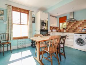 a kitchen with a wooden table and chairs at Beachcliff in Gorran Haven