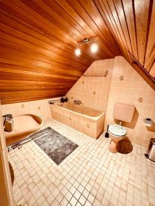 ein Badezimmer mit einer Badewanne, einem WC und einem Waschbecken in der Unterkunft Gästehaus zum Alten Feilenhauer in Remscheid