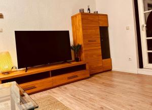 ein Entertainment-Center mit einem Flachbild-TV im Wohnzimmer in der Unterkunft Gästehaus zum Alten Feilenhauer in Remscheid