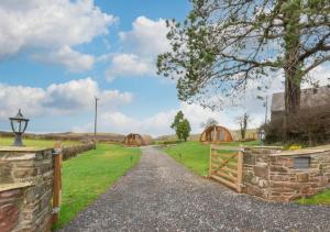 a path through a field with wooden gates and a fence at Oak View in Llanddeusant