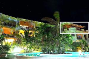 a building with palm trees in front of a pool at Attico con terrazza sulla spiaggia, giardino, piscina, clima, wi-fi in Watamu