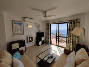 a living room with a couch and a view of the ocean at R1371 Capistrano Playa 417 in Nerja