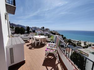 a balcony with a table and chairs and the ocean at R1371 Capistrano Playa 417 in Nerja