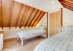 two beds in a room with wooden walls at Ysgubor Wen in Llanrwst