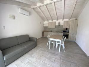 - un salon avec un canapé, une table et des chaises dans l'établissement Villetta 6 La Caletta, à La Caletta