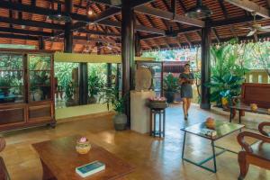 a woman walking through a room with a statue in it at Pandora Suite D'Angkor in Siem Reap