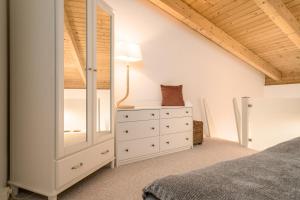 een slaapkamer met een witte dressoir en een spiegel bij Ferienwohnung Zwischen den Seen in Vietzen