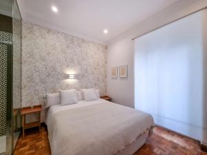 een slaapkamer met een groot wit bed en een raam bij Magallanes - Iberorent Apartments in San Sebastian