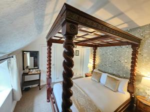 a canopy bed in a bedroom with a mirror at College Arms in Stratford-upon-Avon