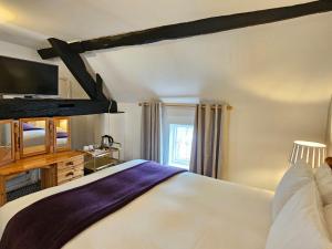 1 dormitorio con 1 cama grande y TV en College Arms en Stratford-upon-Avon