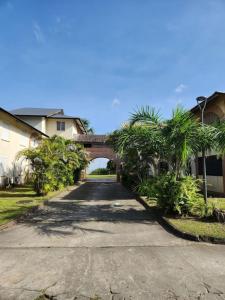 a road with a bridge and palm trees and a house at Hello-Guyane, Marina 4, Studio Prestige 5 étoiles in Saint-Laurent du Maroni