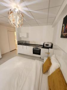 a white room with a couch and a kitchen at Hello-Guyane, Marina 4, Studio Prestige 5 étoiles in Saint-Laurent du Maroni
