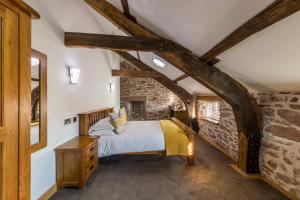 a bedroom with a bed and a brick wall at Gosforth Hall Inn in Gosforth