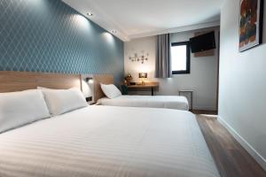 a hotel room with two beds and a table at KYRIAD DIRECT ORLEANS NORD - Cap Saran in Saran