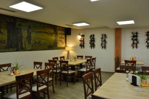 a restaurant with tables and chairs and a painting on the wall at Vila Voždov Konak in Rača