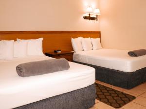 una habitación de hotel con 2 camas en una habitación en Kiskadee Korner Vacations, en Buccoo